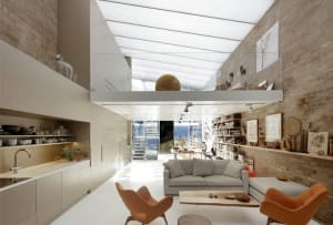 Modern interior design featuring an open-plan living area with brick, concrete, and glass