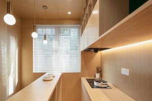 A modern kitchen with wooden panels and stainless steel appliances.