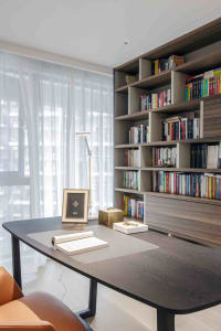 Modern office library featuring a wooden bookshelf with numerous books.