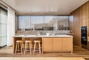 Modern kitchen with wooden cabinets and a large window.