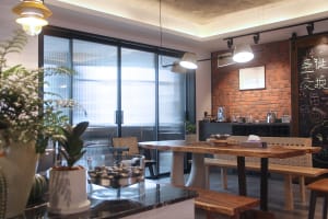 Modern cafe interior with wooden table, concrete floors, and brick wall