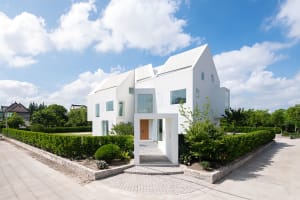 A modern white house with a unique architectural design.