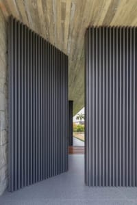 A modern architectural design featuring a wall composed of vertical concrete panels.