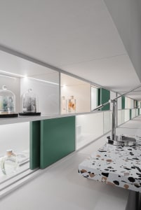 Modern showroom with glass cabinets, marble surfaces, and metallic accents.