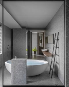 A minimalistic bathroom with a freestanding bathtub made of terrazzo