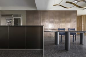 Modern industrial kitchen with metal panels and dark countertops.