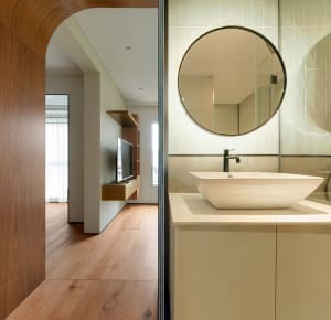 A minimalist bathroom featuring white tiles, a modern sink, and wooden flooring.