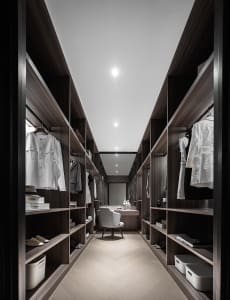 Modern industrial-style closet with wooden shelves and clothing items.