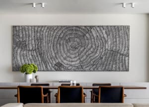 A modern interior space featuring a large abstract wall art with concentric circular patterns.