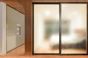 A modern library interior featuring sliding glass doors with textured glass panels.
