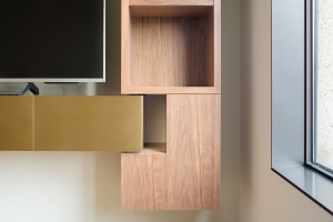 A modern interior design featuring a wooden accent wall and floating shelves.