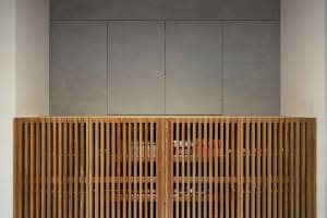 A modern storage cabinet with wood slats and a sleek, minimalist design.