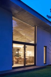Modern minimalist kitchen interior featuring sleek concrete and glass materials.