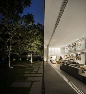 A modern minimalist living room featuring concrete flooring and walls.