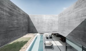 A modern exterior design with concrete walls and a pool.