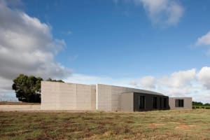 Modern house with a concrete exterior in an open field.