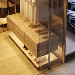 A minimalist wooden closet with glass doors and drawers, showcasing stylish and functional design