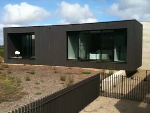 A modern black facade with a metal exterior and large windows.