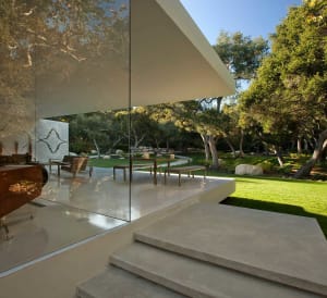 Modern minimalist interior design featuring clean lines, glass walls, concrete flooring, and stone accents.