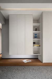 Modern minimalist storage shelves with white doors, featuring open shelving and decorative items on the right side.