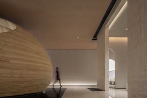 A modern minimalist office space featuring wood, concrete, and stone materials.