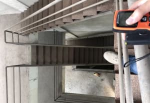Concrete staircase with metal railings and a small piece of food on the floor.