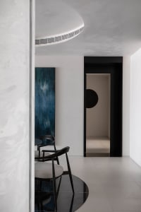 A minimalist interior design featuring concrete walls and furniture.