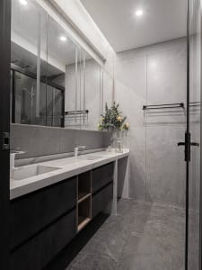 Modern bathroom with marble tiles, double sink vanity, and walk-in shower.