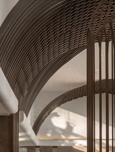 Modern interior design featuring a metallic mesh ceiling and curved lines.