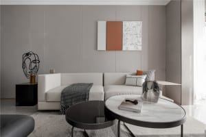 A modern minimalist living room featuring neutral-toned furniture and decor.