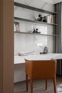 Modern office space featuring a desk made of marble and a chair upholstered in leather.
