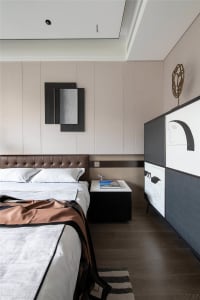 Modern bedroom featuring wooden flooring and fabric bedspread, with minimalist decor and a minimalist side table.