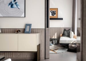 Modern living room featuring wood-paneled walls and a white upholstered chair with a black and white abstract painting hangin