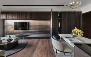 Modern living and dining room featuring metallic elements and wooden panels.