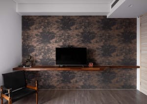 A modern living room featuring a wooden wall with a mounted television and a sleek, black chair.