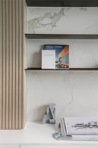 Modern marble shelves with books and architectural models.