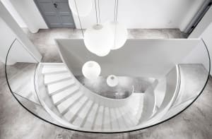 A minimalist staircase with a glass railing and concrete steps.