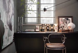 A modern home office with a desk, chair, and various decorative items.