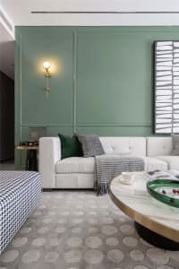 Modern living room featuring a textured white couch, patterned rug, and metallic coffee table.