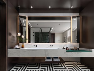 A modern bathroom interior featuring marble fixtures and geometric flooring patterns.