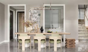 Modern dining room featuring a wooden table, green chairs, and decorative elements.