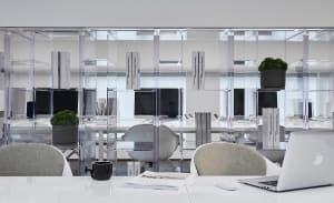 A modern workspace featuring glass shelves and minimalist design.