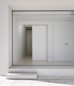A minimalist modern entryway with a concrete floor and walls.