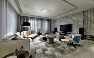 A modern living room with marble accent walls and leather furniture.