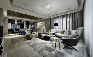 A contemporary living room featuring a spacious marble floor, a comfortable sofa, and modern furniture.