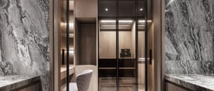 A modern minimalist closet with marble walls and wooden shelves.