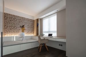 A modern, minimalist small space interior design with a wooden chair and built-in shelves.