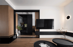 Modern interior space with wooden furniture, black wall elements, and a flat-screen TV.