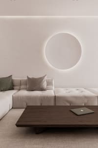 A minimalist living room featuring a modern sofa with a backlit circular design.