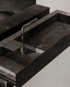 A modern luxury kitchen with a marble countertop and sink.